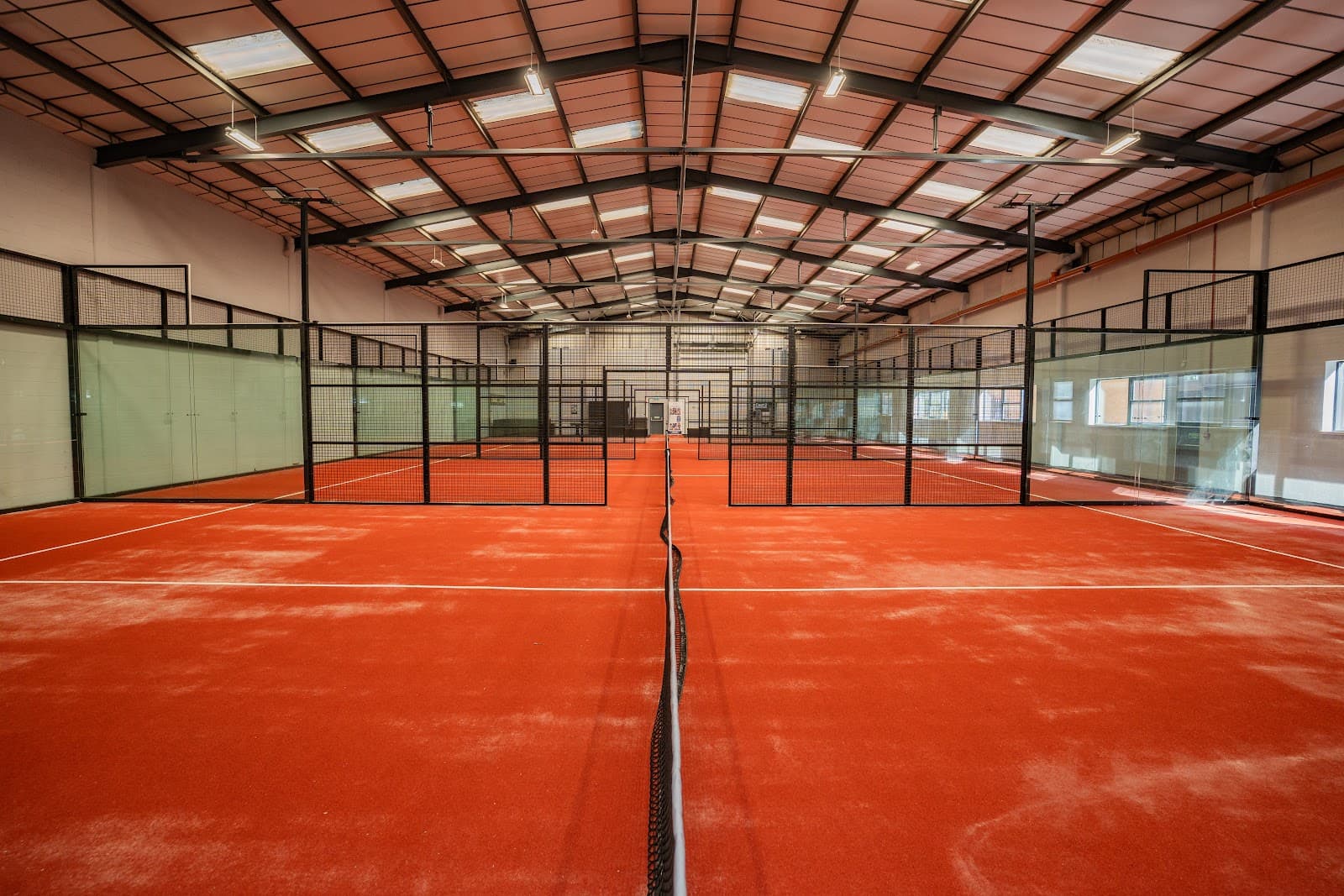 Indoor terracotta padel courts at Padel and Coffee